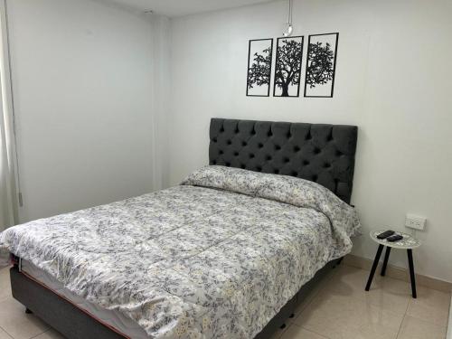 a bedroom with a bed with a black headboard at Tu casa en Ipiales in Ipiales