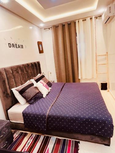 a bedroom with a bed with purple sheets and a rug at Aéroport appartement Dar Nahila in Marrakech