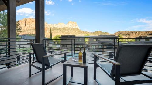 a balcony with two chairs and a bottle of wine at Montclair at Zion in Springdale