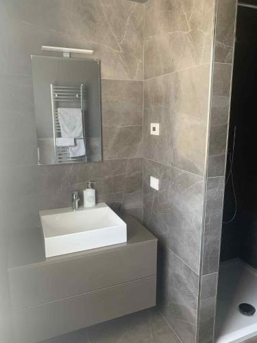 a bathroom with a white sink and a mirror at SirmioGarda House in Sirmione