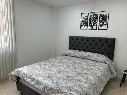a bedroom with a bed with a comforter on it at Tu casa en Ipiales in Ipiales