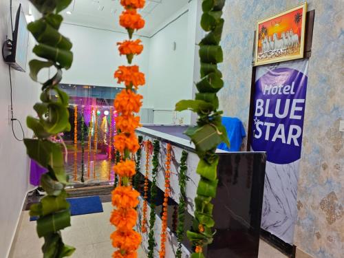 a room with a blue star sign and orange and green flowers at Hotel Blue Star Alwar in Alwar