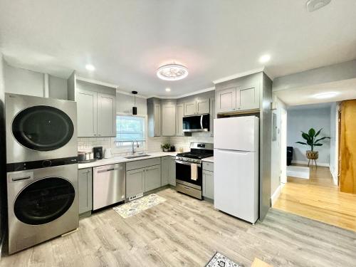 a kitchen with stainless steel appliances and white cabinets at Cozy 3-Beds in 2-Bedrooms Apartment Near Quincy Adams in Quincy