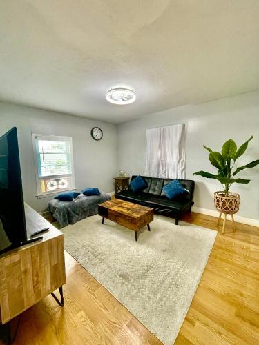 a living room with a couch and a tv at Cozy 3-Beds in 2-Bedrooms Apartment Near Quincy Adams in Quincy