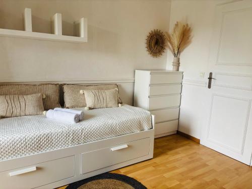 Un dormitorio con una cama blanca y una cómoda. en Smart stay entre la defense et paris, en Argenteuil