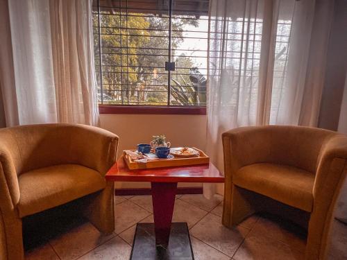 a room with two chairs and a table and a window at Hotel Pousada do Bosque in Canela