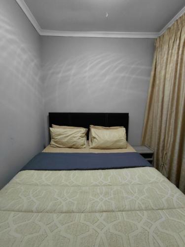 a small bedroom with a bed with a bedspread and pillows at Mont Pelaan 88 in Newcastle
