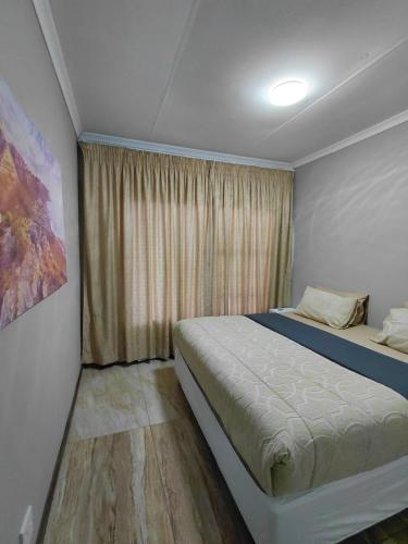 a small bedroom with a bed and a window at Mont Pelaan 88 in Newcastle