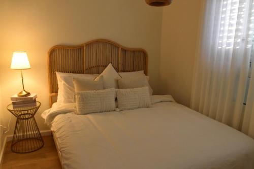 a bed with white sheets and pillows in a bedroom at כרמי הכפר in Kefar Barukh