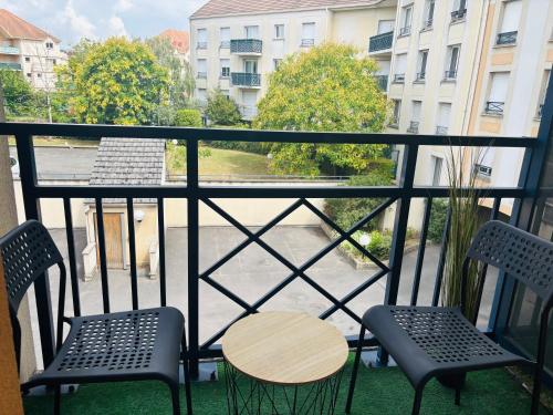 Un balcón con dos sillas y una mesa y una vista. en Smart stay entre la defense et paris, en Argenteuil