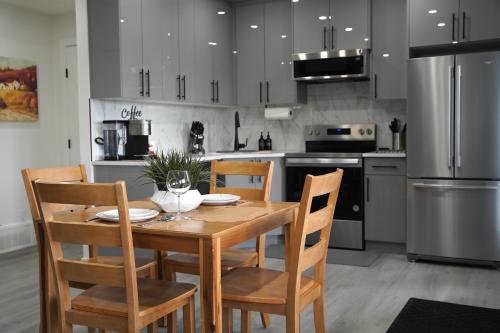 a kitchen with a wooden table with chairs and a refrigerator at The Cozy Nook of Seton in Calgary