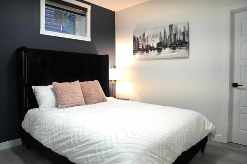 卡尔加里The Cozy Nook of Seton的一间卧室配有带白色床单和粉红色枕头的床。