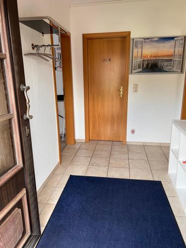 a hallway with a door and a blue rug at Ferienwohnung am Nürburgring in Siebenbach