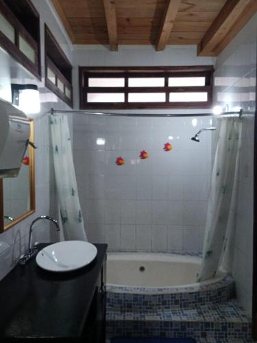 a bathroom with a shower and a sink and a tub at Hotel El Recreo Lanquín-Champey in Lanquín