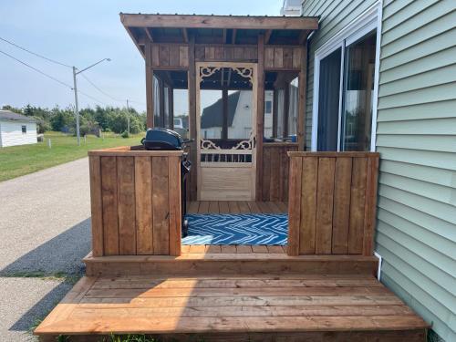 a porch with a wooden door on the side of a house at Chez Thomas, la maison du pêcheur in Grande Anse