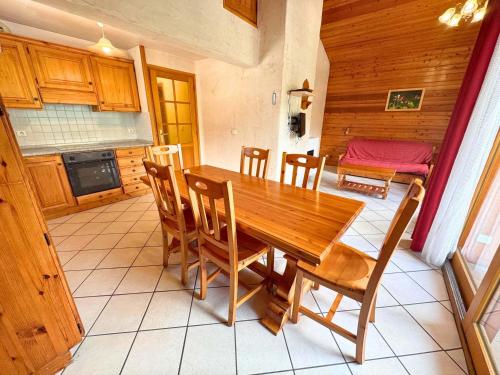 une cuisine et une salle à manger avec une table et des chaises en bois dans l'établissement Appartement Confortable 85m² pour 6 Pers. avec Terrasse, à 300m des Pistes à St Martin de Belleville - FR-1-452-382, à Saint-Martin-de-Belleville