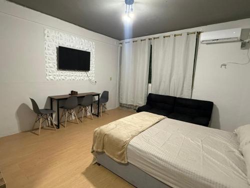 a bedroom with a bed and a table with chairs at cachito de cancun in Cancún