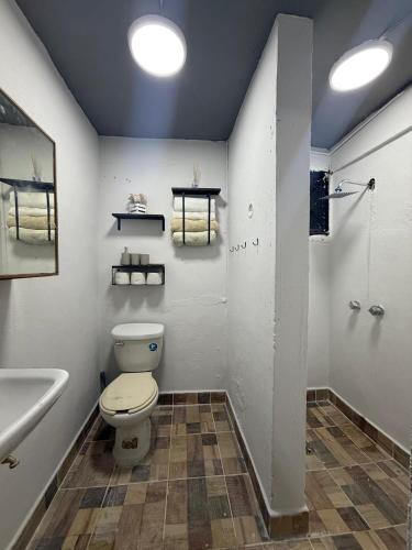 a bathroom with a toilet and a sink and a shower at cachito de cancun in Cancún