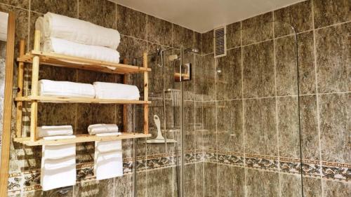a bathroom with a shower and shelves with towels at DiCaprio - Sunset Ritual incl I by MovieStar Holidays in Mijas Costa