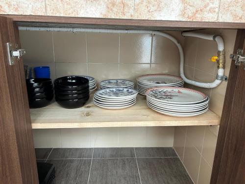 a cabinet filled with plates and bowls on a shelf at Tu casa en Ipiales in Ipiales