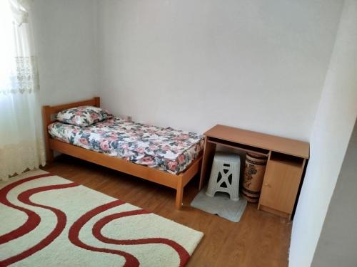 a bedroom with a bed and a table and a rug at Kuća Duskic in Kunje