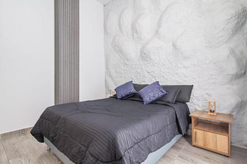 a bedroom with a bed with purple pillows at 6 bedroom with Jacuzzi 1 block from LLeras P10 in Medellín