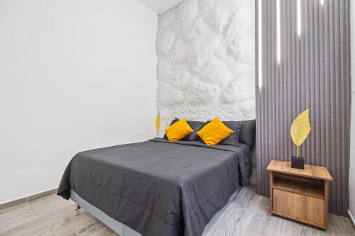 a bedroom with a bed with yellow pillows and a table at 6 bedroom with Jacuzzi 1 block from LLeras P10 in Medellín