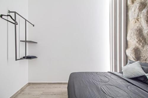 a bedroom with a bed and a white wall at 6 bedroom with Jacuzzi 1 block from LLeras P10 in Medellín