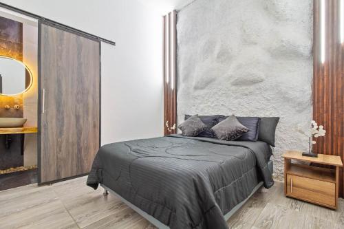 a bedroom with a bed with a concrete wall at 6 bedroom with Jacuzzi 1 block from LLeras P10 in Medellín