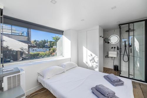 Un dormitorio blanco con una cama y una ventana grande. en Villa Jaliel Cannes I 270m2 I Spa I 10 minutes du centre-ville I 12 personnes, en Cannes