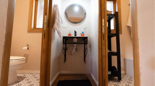 une salle de bain avec toilettes et un miroir au mur dans l'établissement Cabaña en Chapelco Golf San Martin de los Andes 2 Habitaciones, à San Martín de los Andes