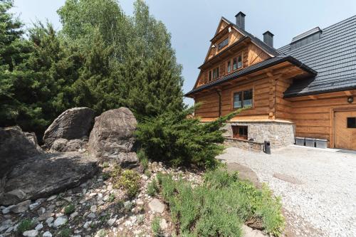 a large wooden house with a rocky yard at Polana Sosny in Niedzica Zamek