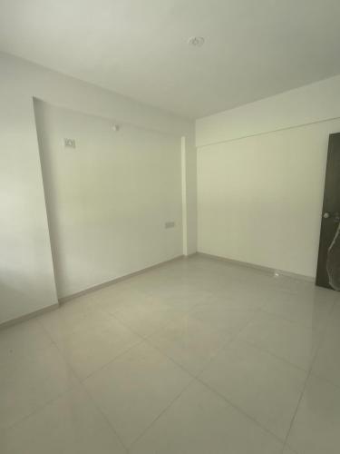 an empty room with white walls and white tile floors at Amrutyog homes in Wai