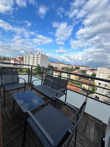 a balcony with chairs and a view of a city at Appartement T3 in Villeurbanne