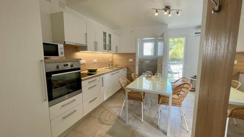 a kitchen with a table and chairs in it at Apartments Villa Agatha in Sveti Filip i Jakov