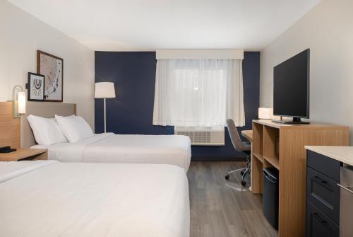 a hotel room with two beds and a flat screen tv at Spark by Hilton West Coxsackie in West Coxsackie