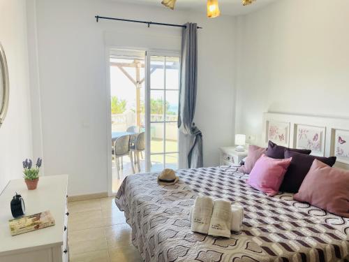 トロクス・コスタにあるCasa Blanca con vistas al mar by At Homeのピンクの枕が付いた大きなベッドのある寝室