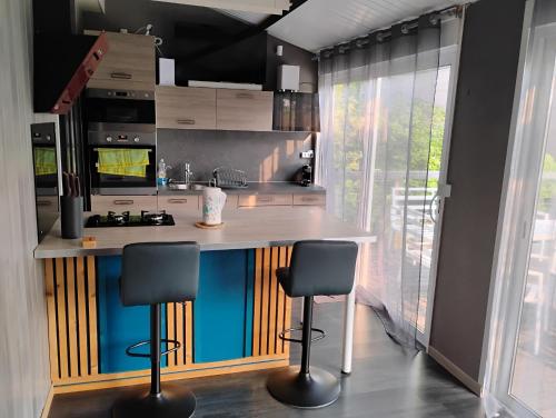 a kitchen with a counter and two stools in it at Cottage in Vaumort