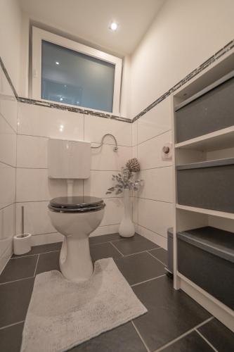 a bathroom with a toilet and a vase of flowers at Ferienwohnung mit Bergblick in Bad Bleiberg in Bad Bleiberg