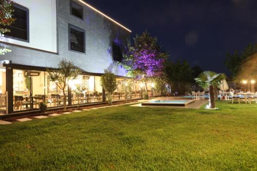 a building with a lawn in front of it at night at İncipark Hotel in Sakarya