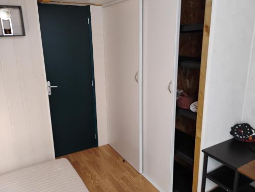 a bedroom with a green door and a closet at Cottage in Vaumort