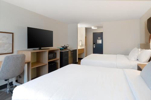a hotel room with two beds and a flat screen tv at Spark by Hilton West Coxsackie in West Coxsackie