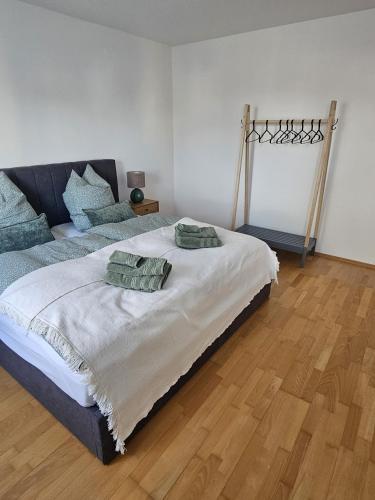 a bedroom with a large bed with two pillows on it at City-Appartment am Mühlbach -Kurpark in Bad Aibling