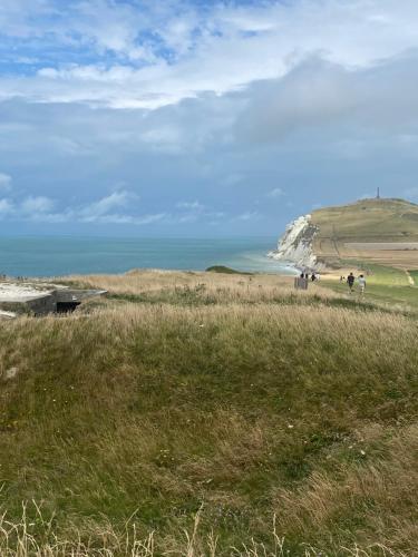 a group of people walking on a beach with a white cliff at Gîte nature M&J in Calais