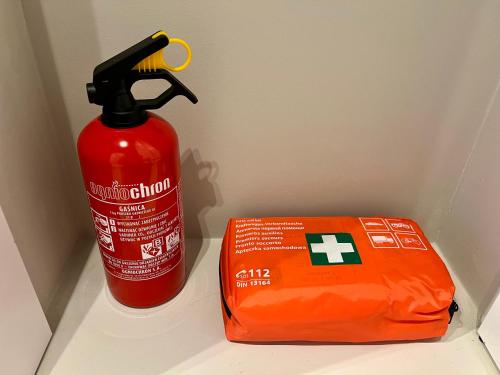 a red fire hydrant next to a fire extinguisher at Boho Apartment - 100m from Market Square in Wrocław