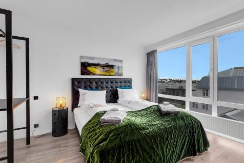 a bedroom with a large bed and a large window at City Center Hotel in Reykjavík