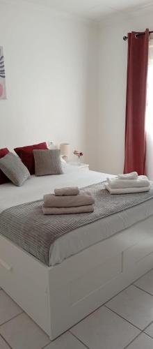 - un grand lit blanc avec 2 serviettes dans l'établissement Logement tout confort Vernet les Bains à côté des thermes, à Vernet-les-Bains