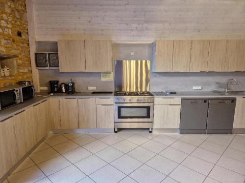 a kitchen with wooden cabinets and a stove top oven at Domaine Garmidou in Lucq-de-Béarn