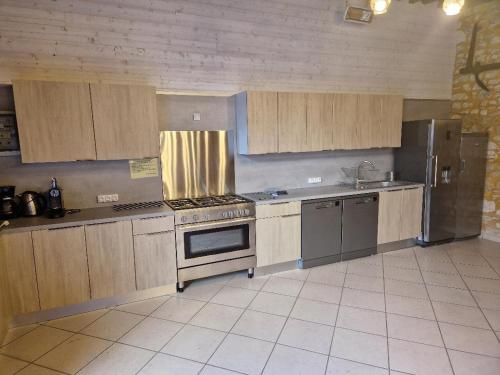 a kitchen with wooden cabinets and a stove top oven at Domaine Garmidou in Lucq-de-Béarn