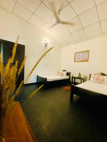 a room with two beds and a ceiling at Zensigiri Ayurveda Wellness Homestay in Sigiriya